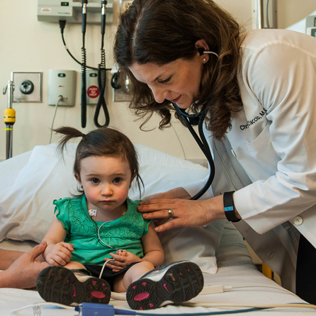 Physician listening to childs lungs